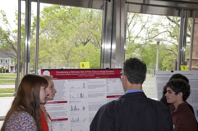 President Michael Roth discusses the poster with students from Prof. Chuck Sanislow's lab.