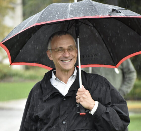 President Michael Roth keeps dry while he watches the Homecoming football game.
