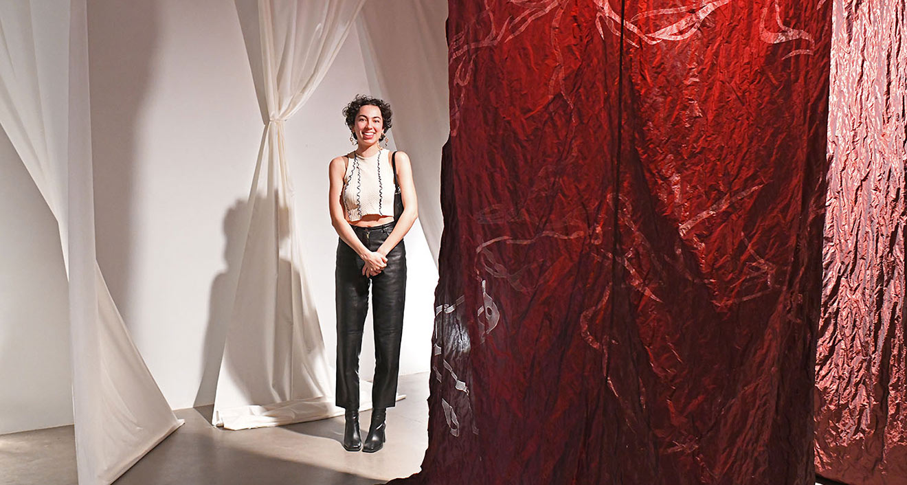 Daniela Sweet-Coll ’22 stands inside her installation, Entretelas, which occupies the entire Zilkha Gallery South space. Sweet-Coll is one of six studio art majors who are displaying their senior thesis projects this week at Zilkha Gallery.
