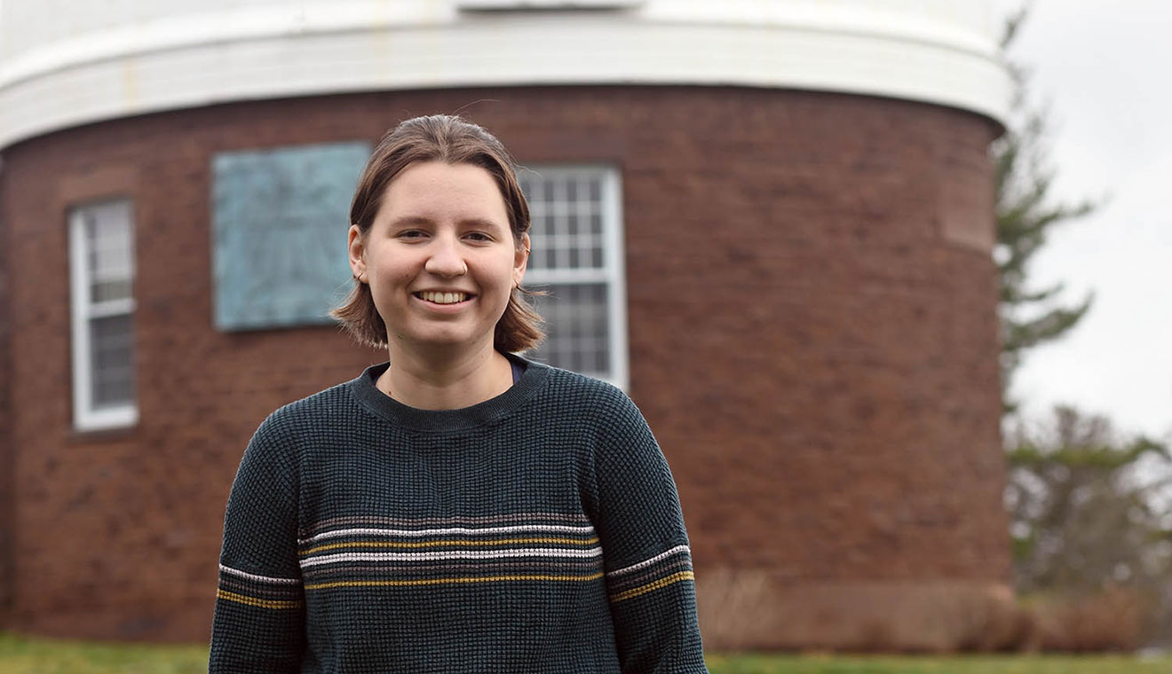Anna Fehr ’23, pictured at Wesleyan’s Van Vleck Observatory, is the recipient of a Barry Goldwater Scholarship, which will support her studies on “Resolving and Modeling the Debris Disk around (exoplanet) HD 106906.” Fehr is challenging existing findings regarding an exoplanet’s rare orbit.