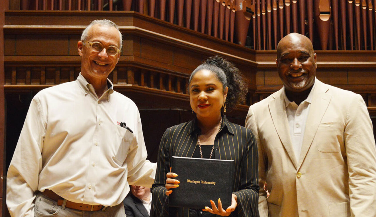 Wesleyan President Michael Roth ’78, at left, and Alumni Association Chair David Hill ’86 present Angela Mae Yee ’97 with a Distinguished Alumni Award on May 21.
