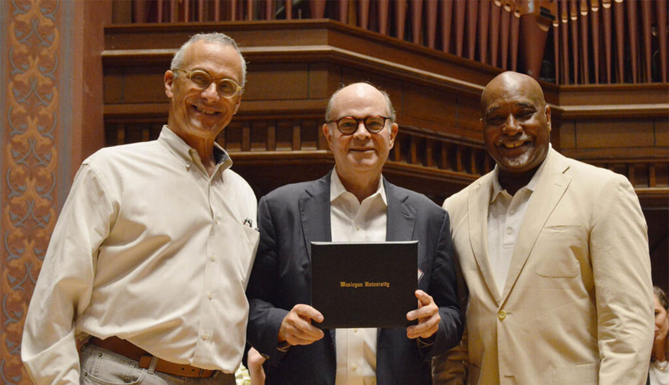 Wesleyan President Michael Roth ’78, at left, and Alumni Association Chair David Hill ’86 present Peter J. Hicks ’72 with an Outstanding Service Award.