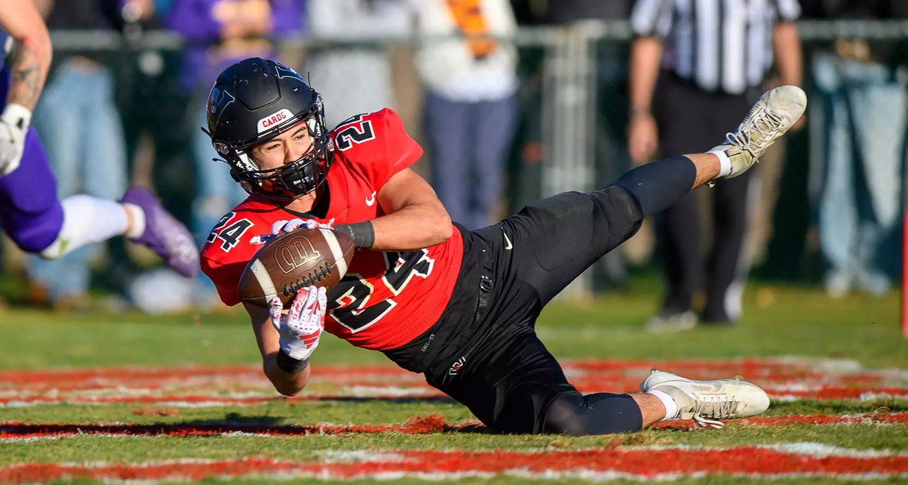 Wesleyan Football's Luke LaCarcina ’26 makes a game-winning, diving catch in the end zone to beat Williams. The Cardinals won its third straight Little Three Championship following the last-second reception. (Photo by Steve McLaughlin Photography)