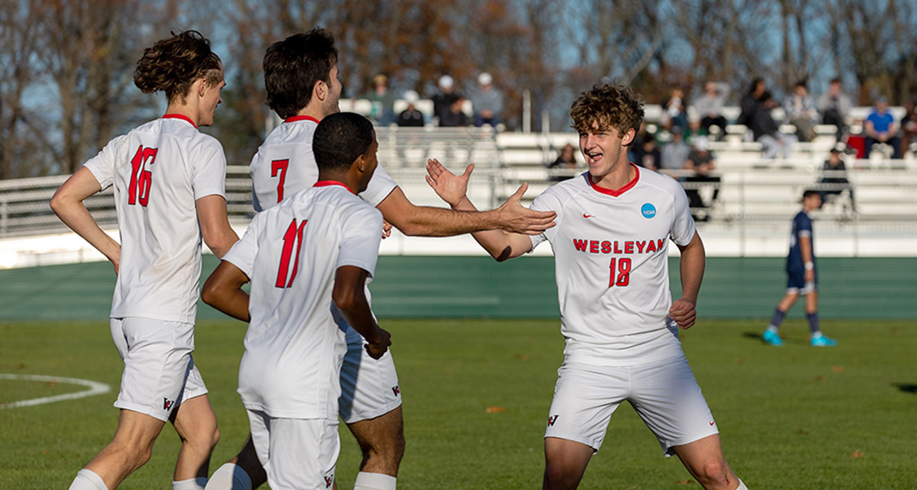 John SennMcNally ’28 (middle) with teammates at Wesleyan men’s soccer’s win over St. Joseph in the first round of the NCAA Championships. (Photo by Jon Endow)