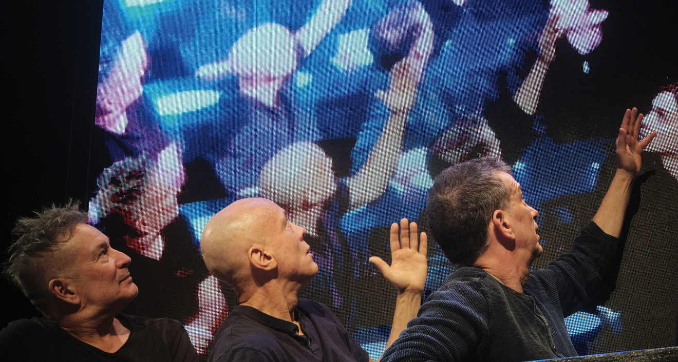 Blue Man Group in front of screen