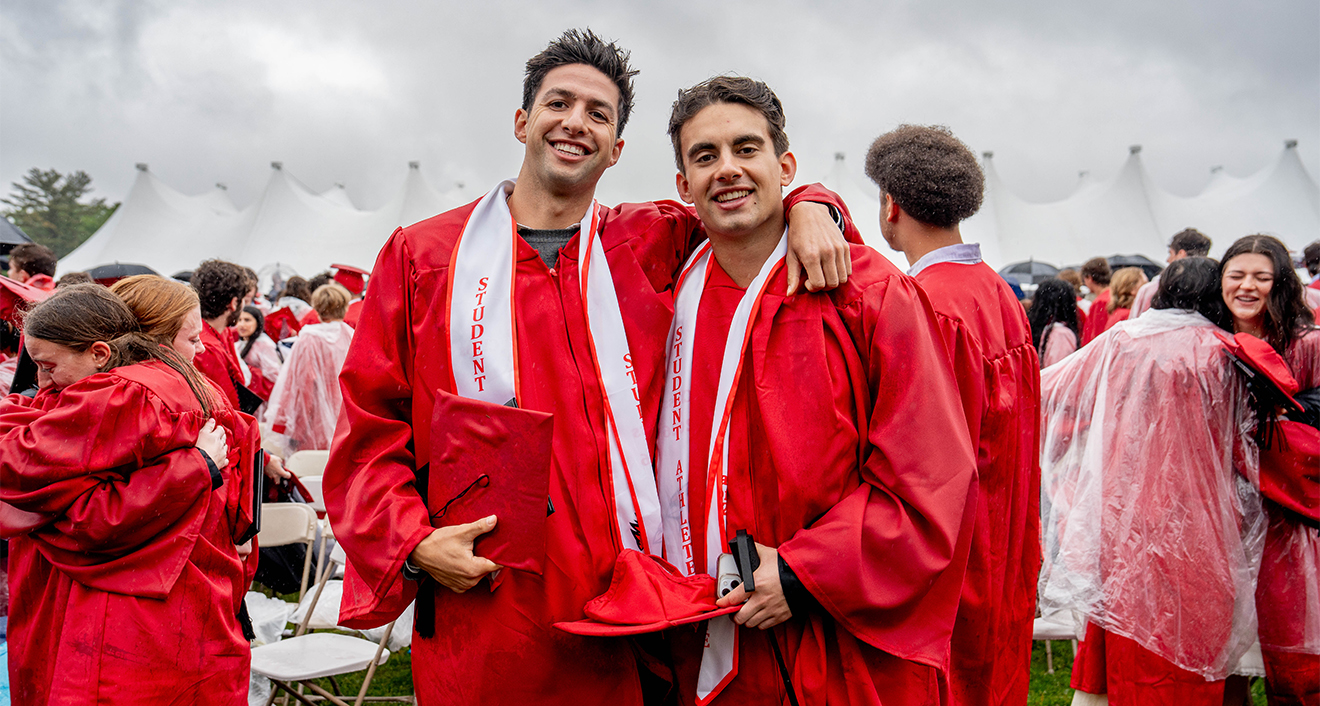 Two graduates holding their diplomas