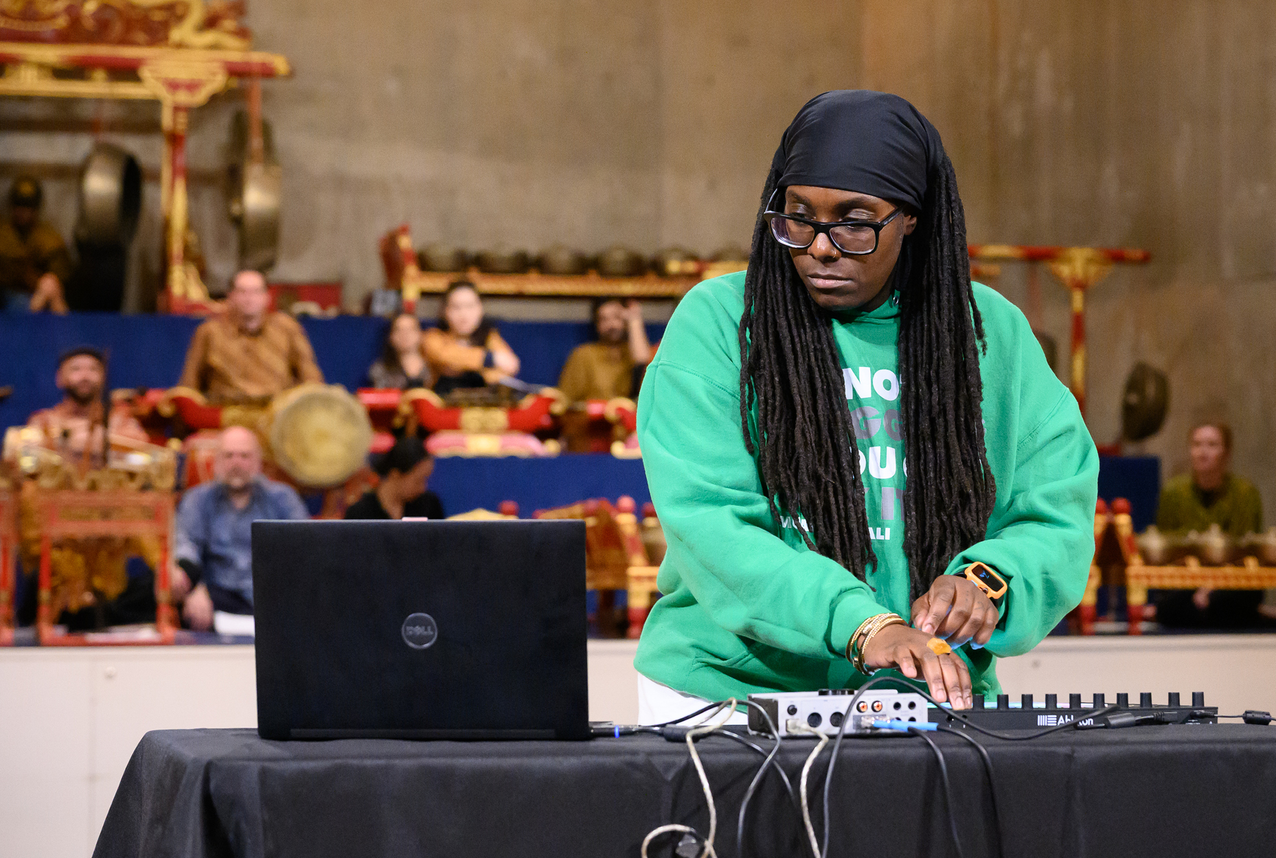 Person playing electronic music with Javanese Gamelan in background 