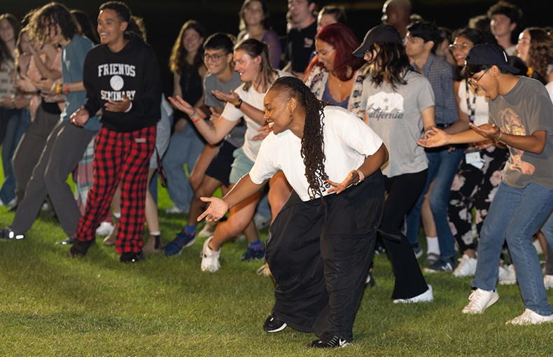 Dancer leading students in a dance on a field 