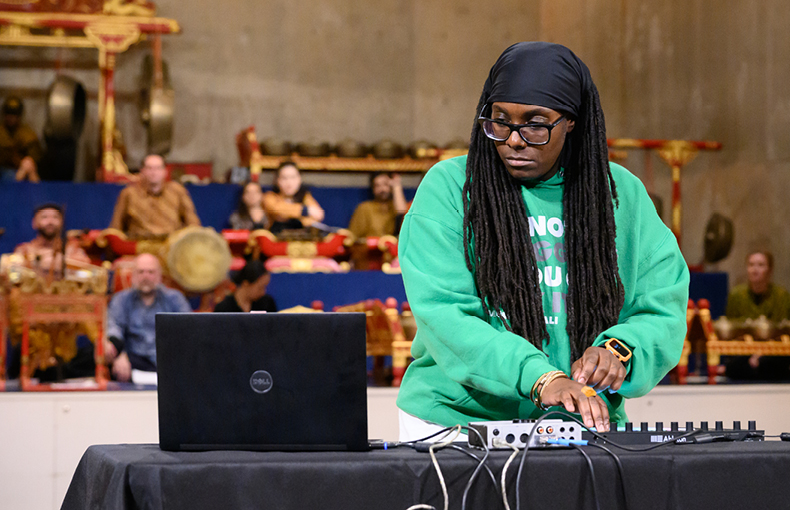 Person playing electronic music with Javanese Gamelan in background 