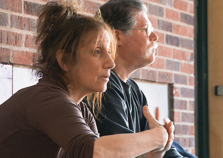 Artist seated and speaking next to faculty member