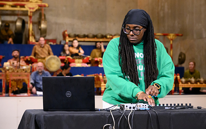 Person playing electronic music with Javanese Gamelan in background 
