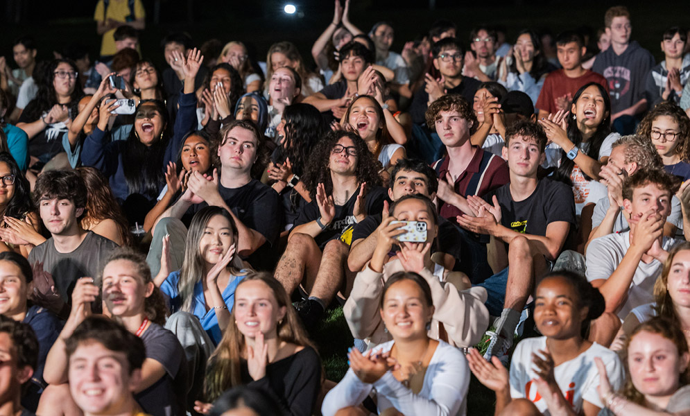 People sitting on field and clapping
