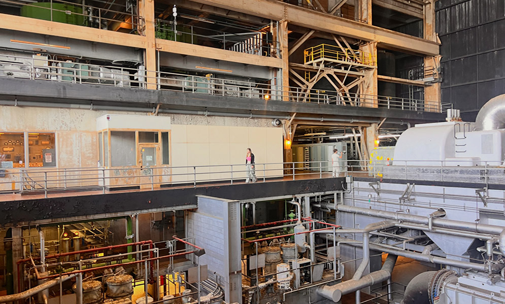 People walking on platform of interior of power plant