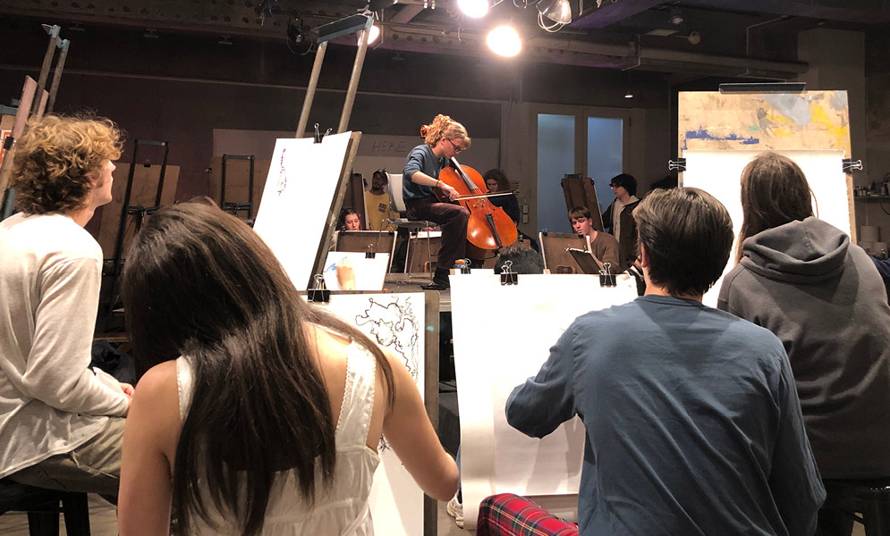 Students drawing musician paying cello platform