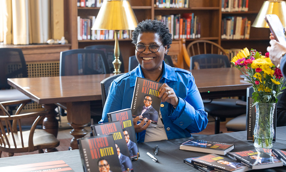 Person holding up book at book signing