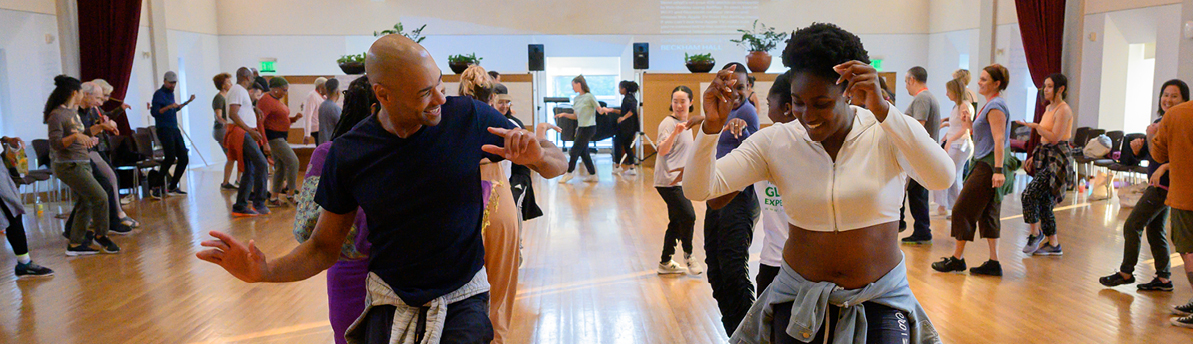 Dancer and student dancing at front of line in workshop 