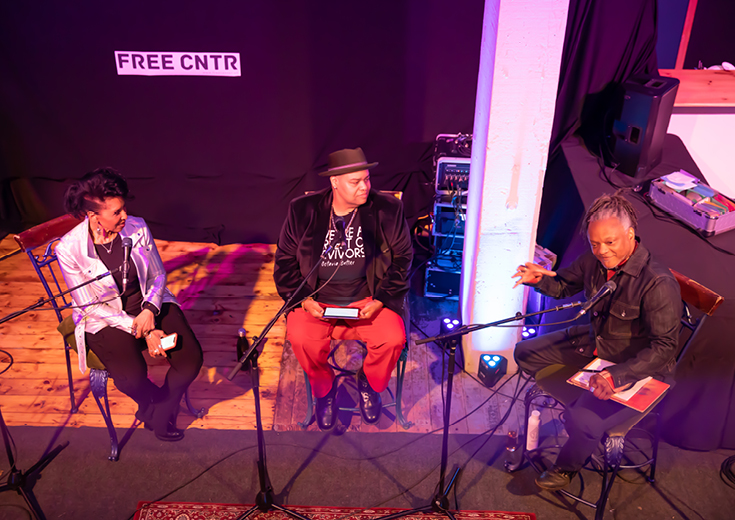 Three musicians on stage discuss their work 