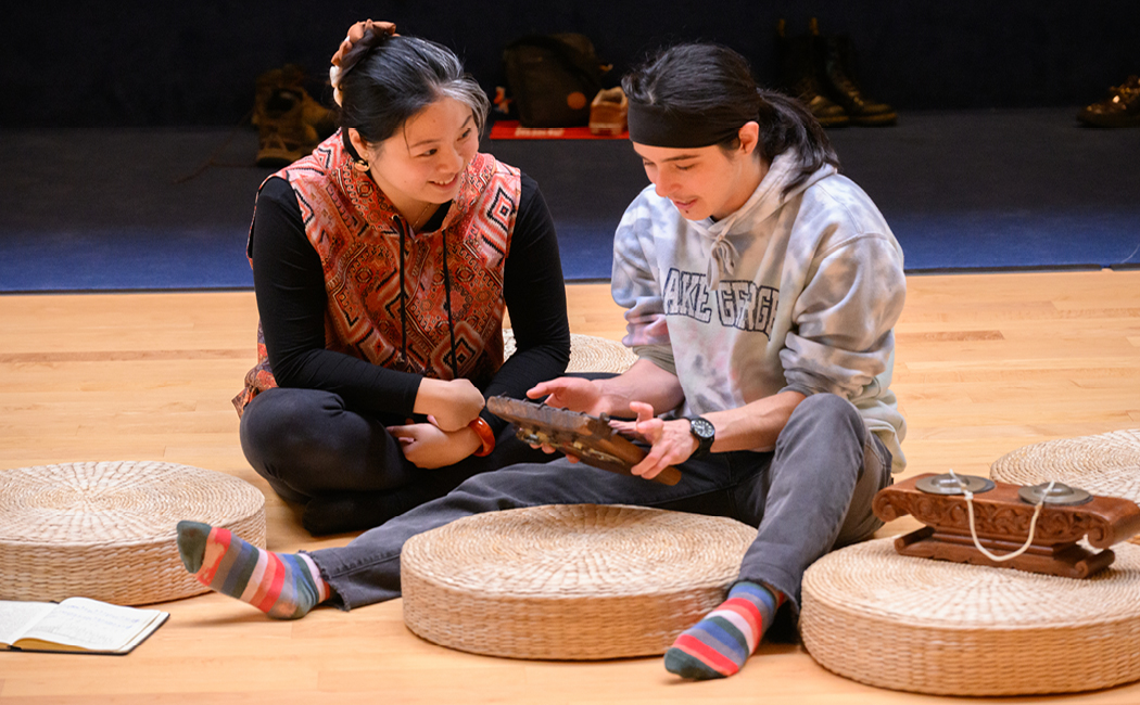 Student introduces another student to instruments from world music collection