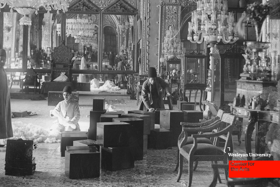 Three men in furnished room with boxes