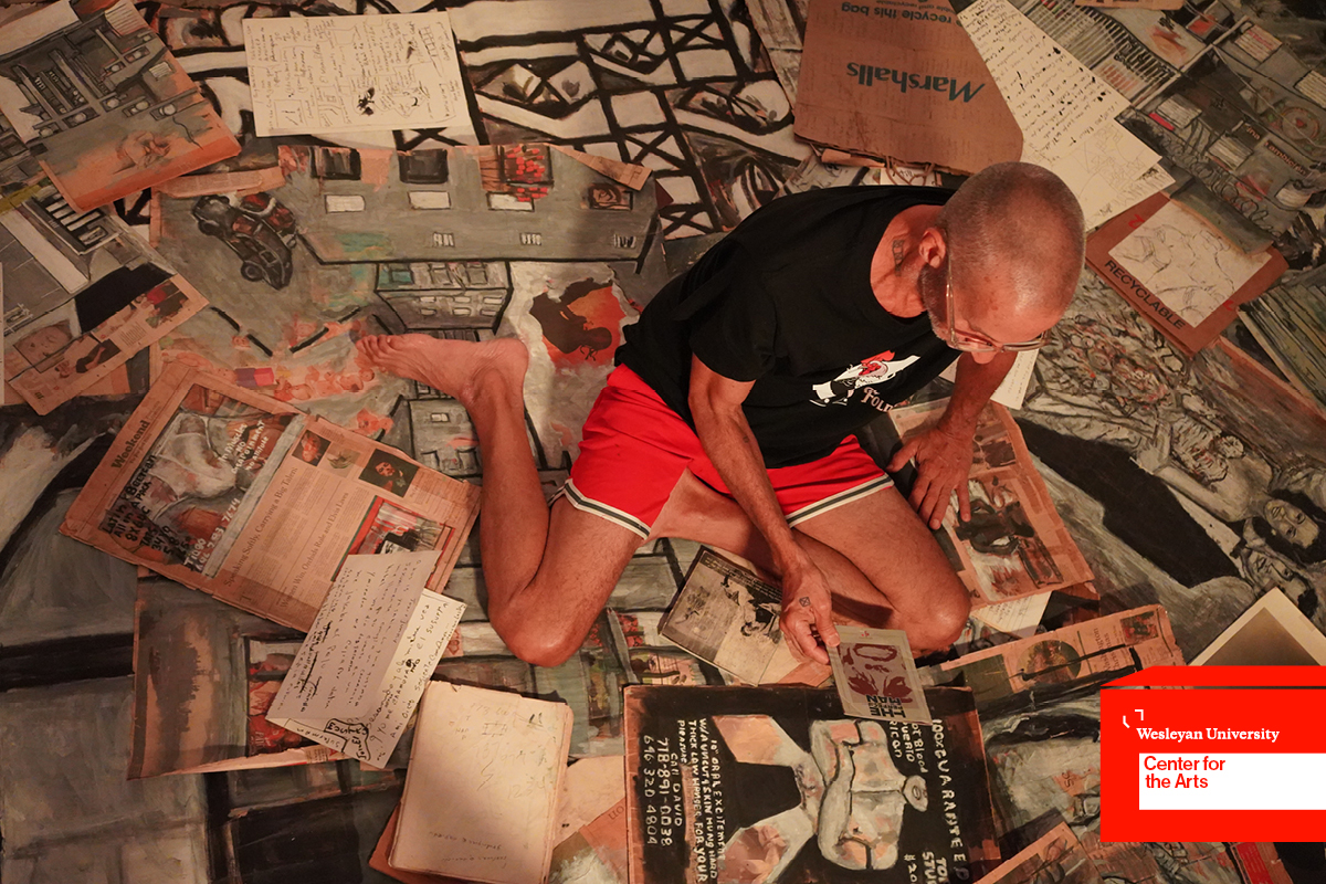 Man sitting in on floor with prints and documents
