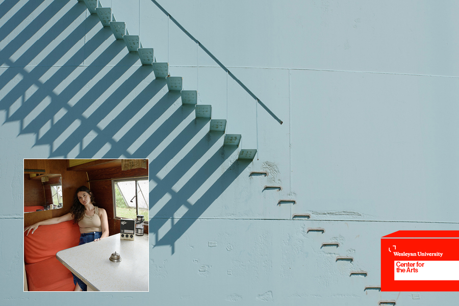 Detail of water tower stairs and woman sitting at table in camper