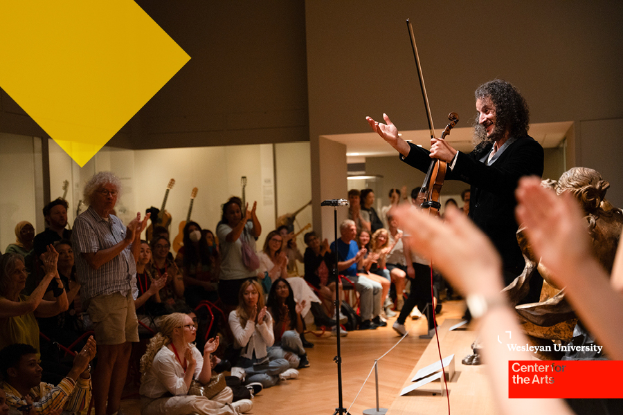Musician with violin on stage greets audience