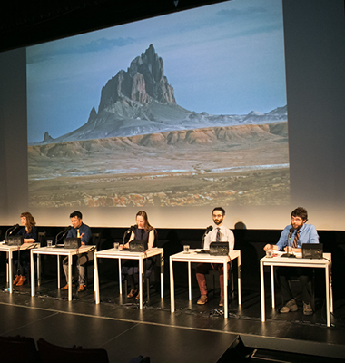 Interior of performing arts hall looking at stage and screen from seats