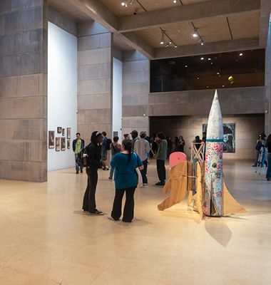 Interior of empty gallery with man standing in distance