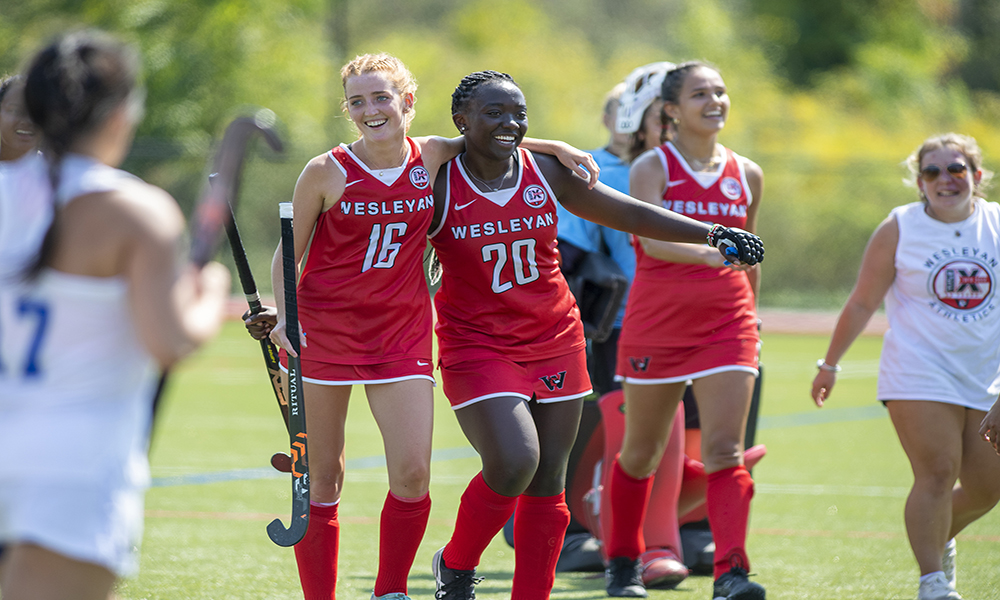 Wesleyan Field Hockey players Georgia Adams '26 and Imani Ochieng '25 celebrate a recent win over Colby 
