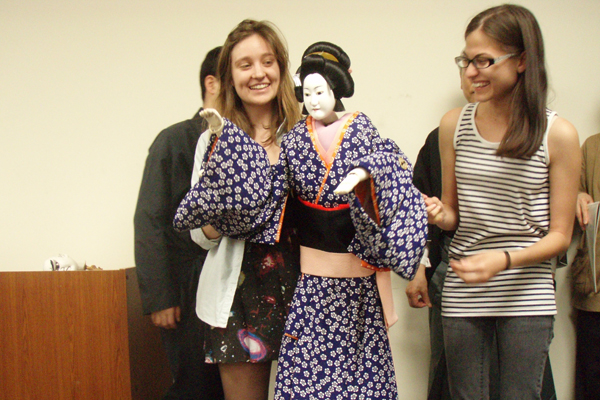 Tessa Young in Hirakata-shi, Japan, at Kansai Gaidai in. Tessa (on left) is attempting to operate the head and right hand of a female ningyo/Bunraku doll backstage at the National Bunraku Theater in Osaka, Japan.